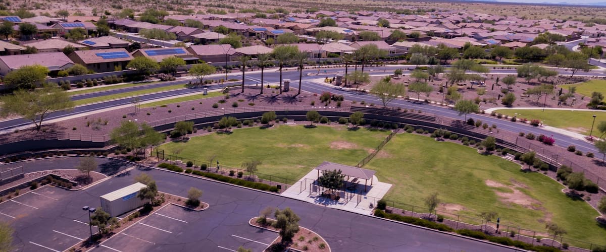 A residential area with houses, roads, and a parking lot.