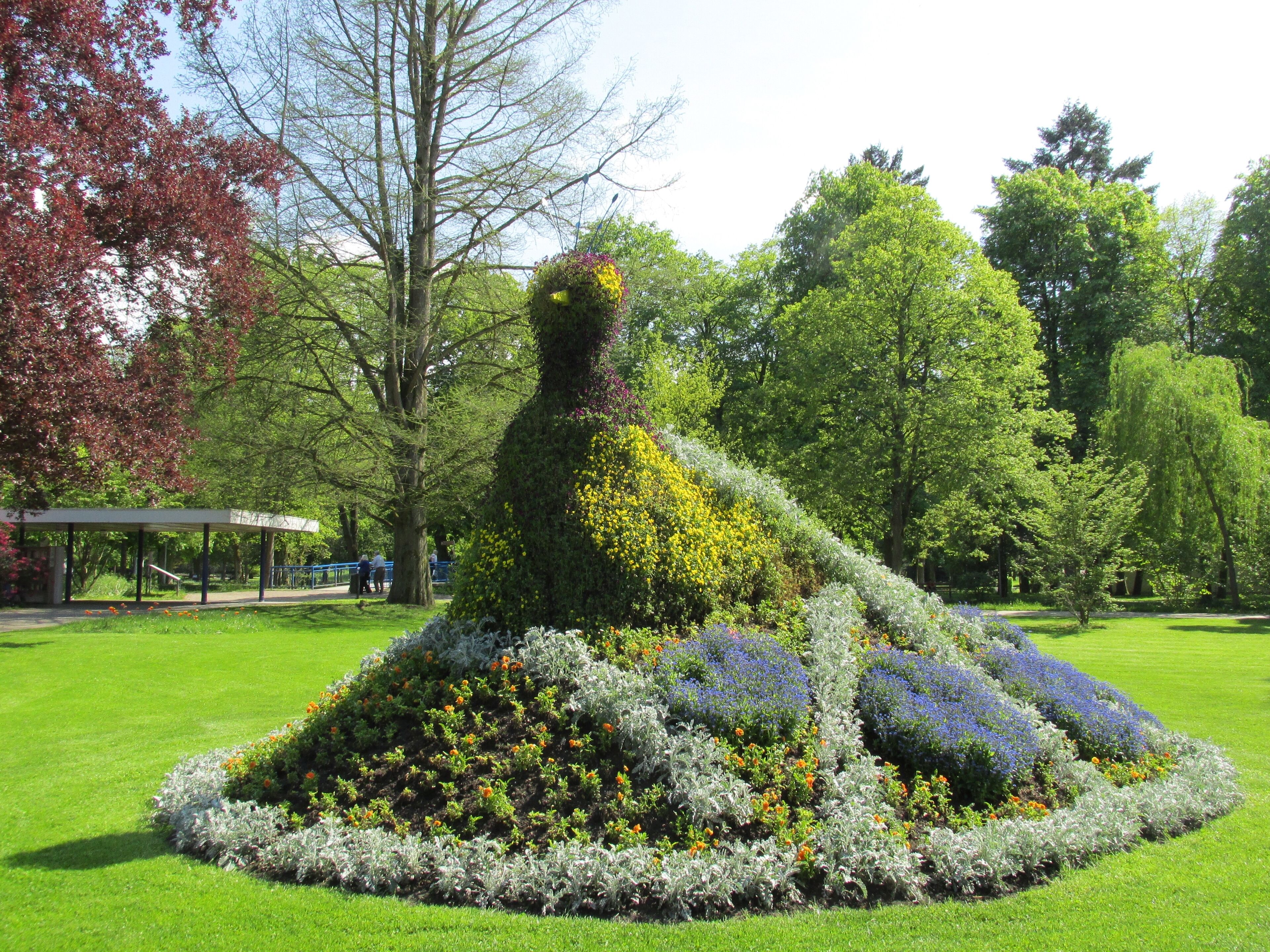 A garden sculpture of a woman surrounded by flowers.