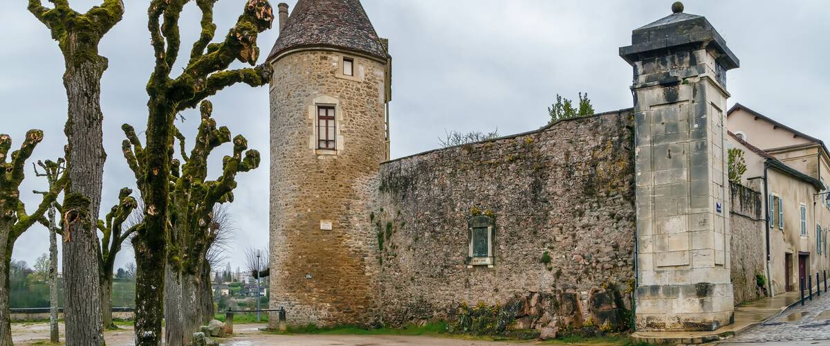 A historic stone building with a tower and a smaller structure.