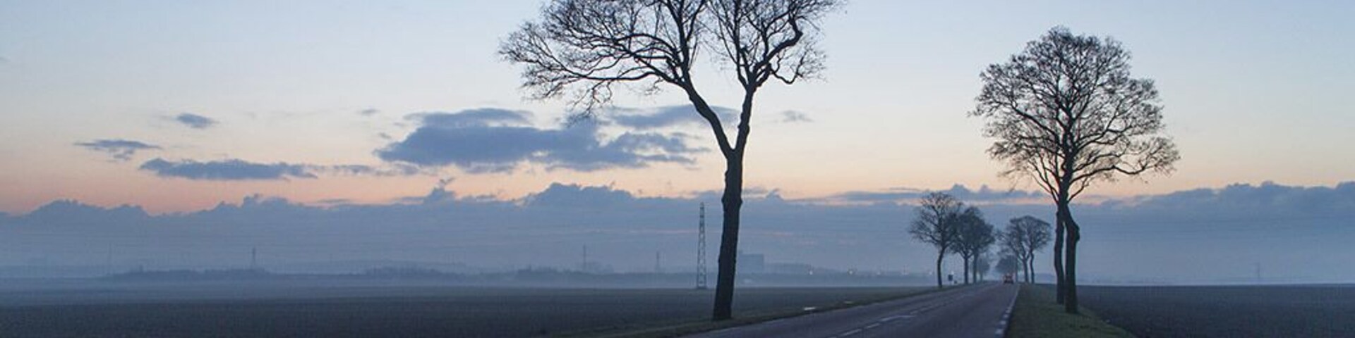 February 2015
Heading back early one morning from our holiday in Morzine, we watched the sunrise as we travelled. Arriving at this spot I couldn't resist stopping for a photo, the industrial landscape in the background with the mist in front and the road and trees in the foreground just worked!