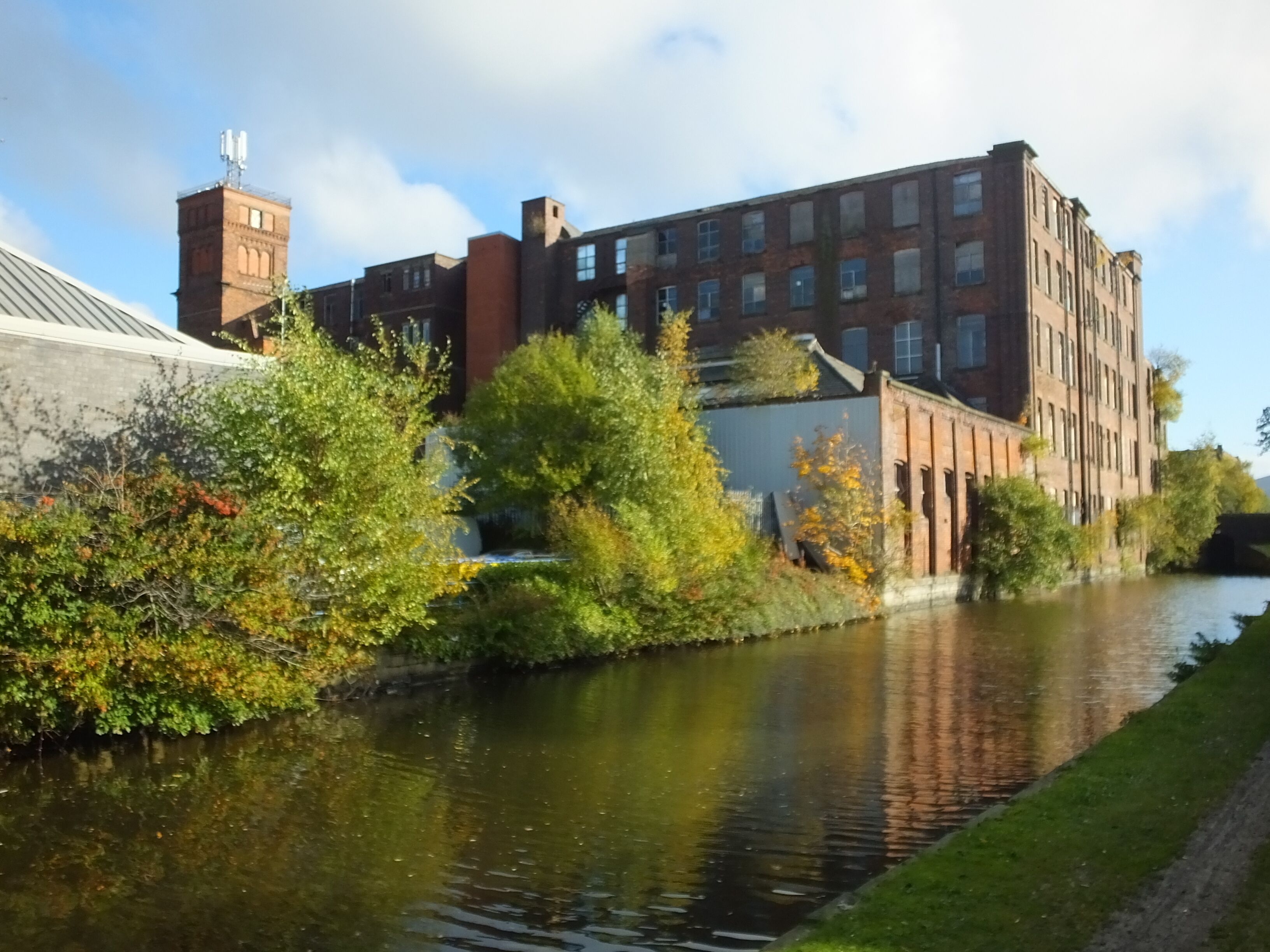 A river with a brick building and a tower on the left.