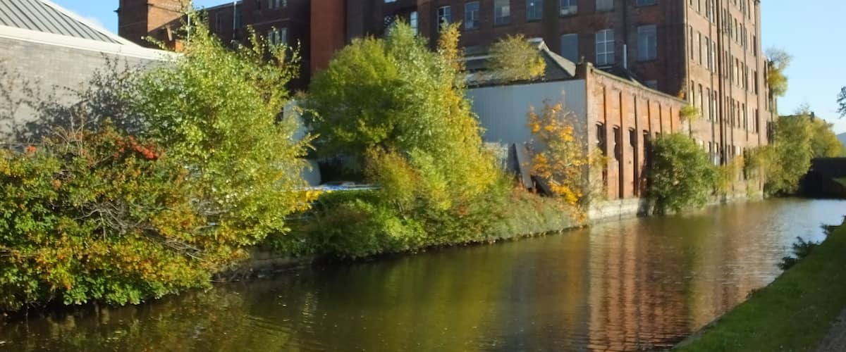A river with a brick building and a tower on the left.