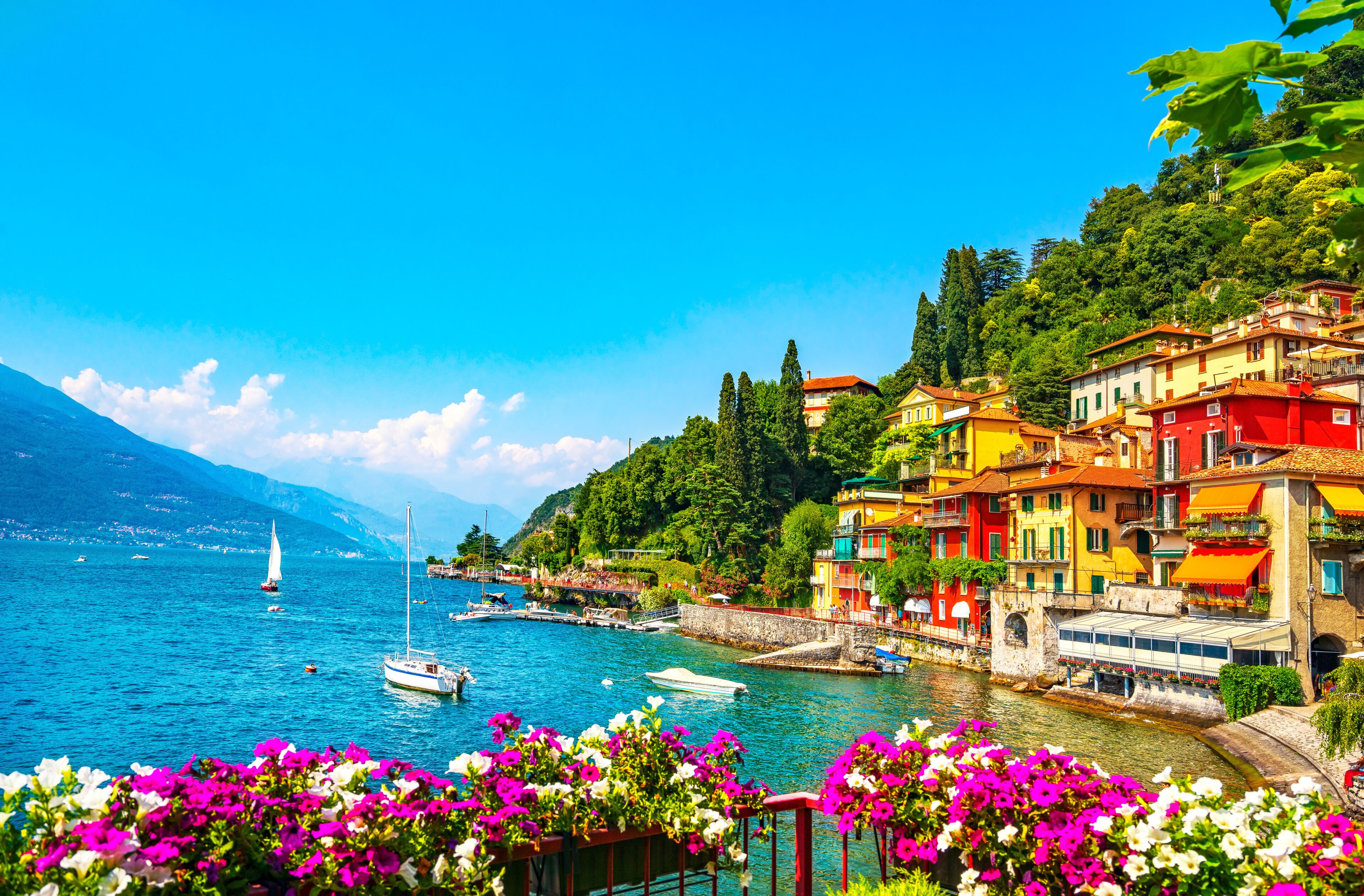 A coastal town with colorful buildings, a clear blue sea, and boats.