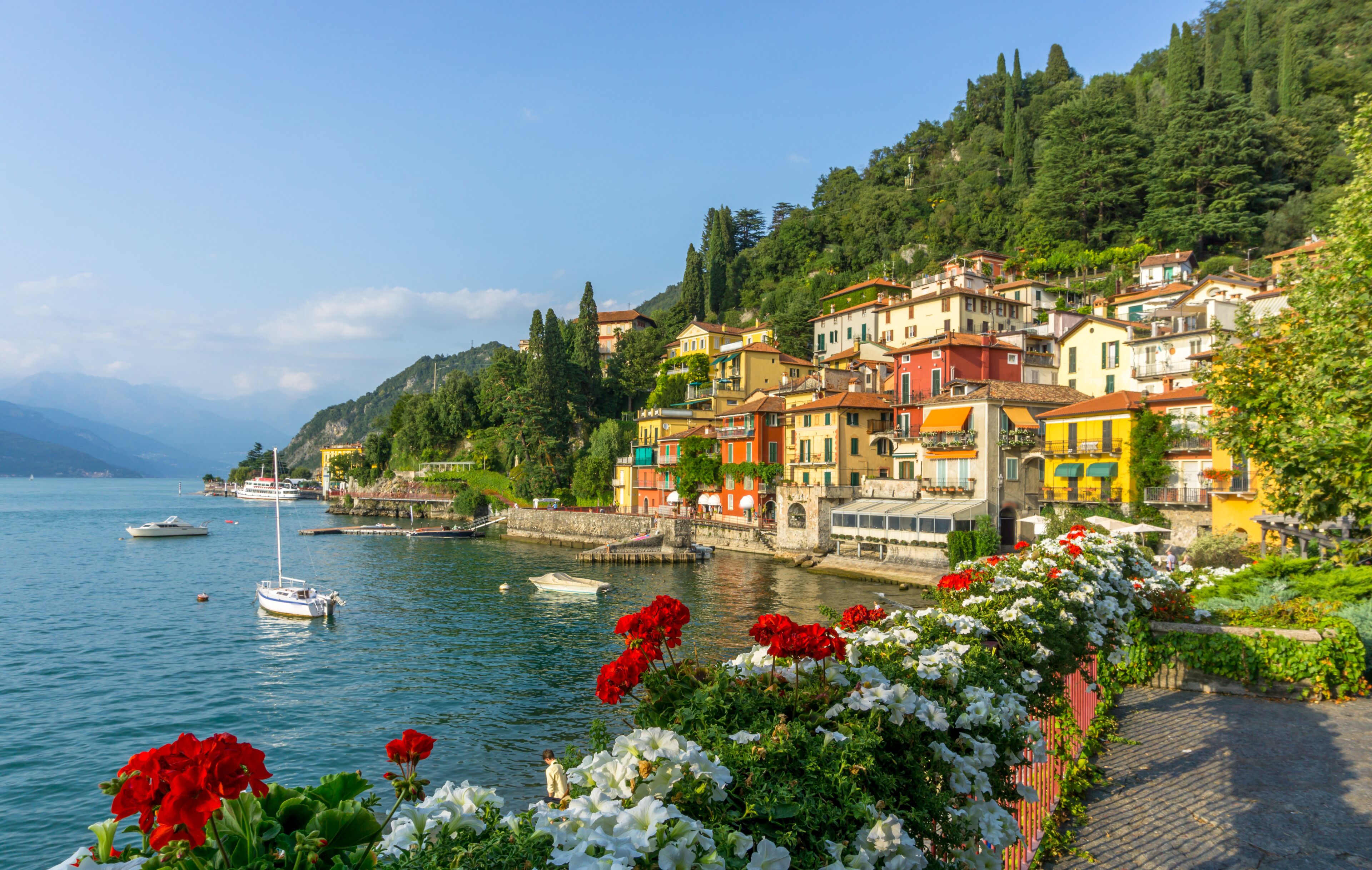 A coastal town with colorful buildings, a calm lake, and boats.