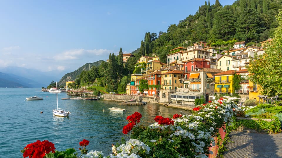 A coastal town with colorful buildings, a calm lake, and boats.