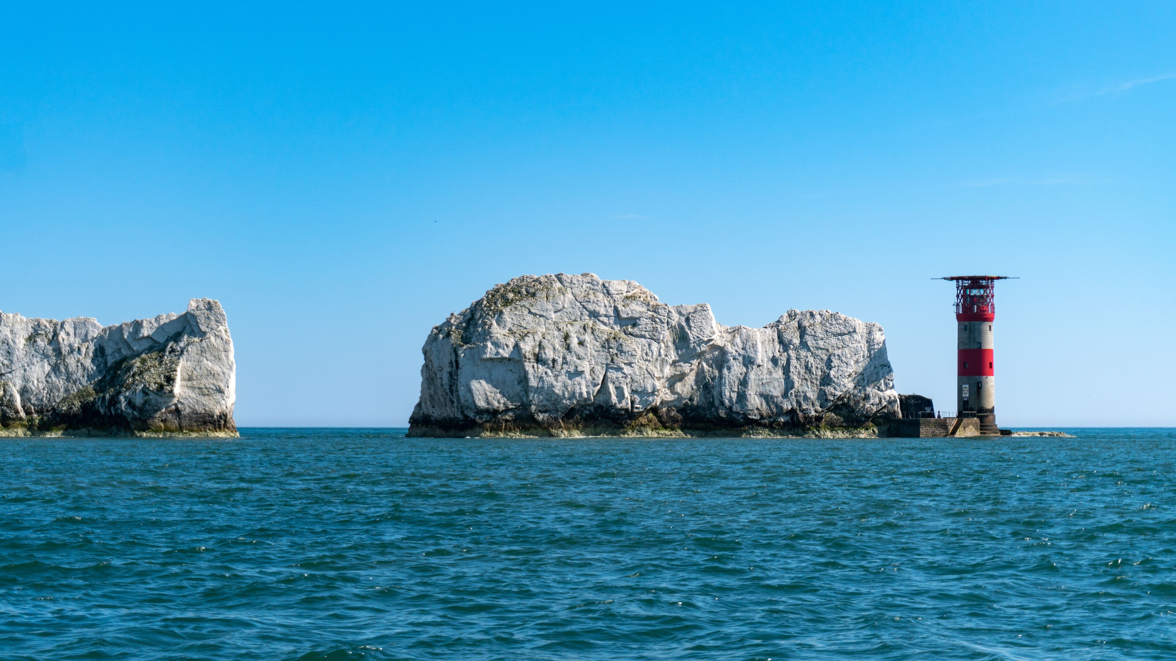 View of The Needles Lighthouse and chalk rocks in Alum Bay, Isle of Wight, United Kingdom