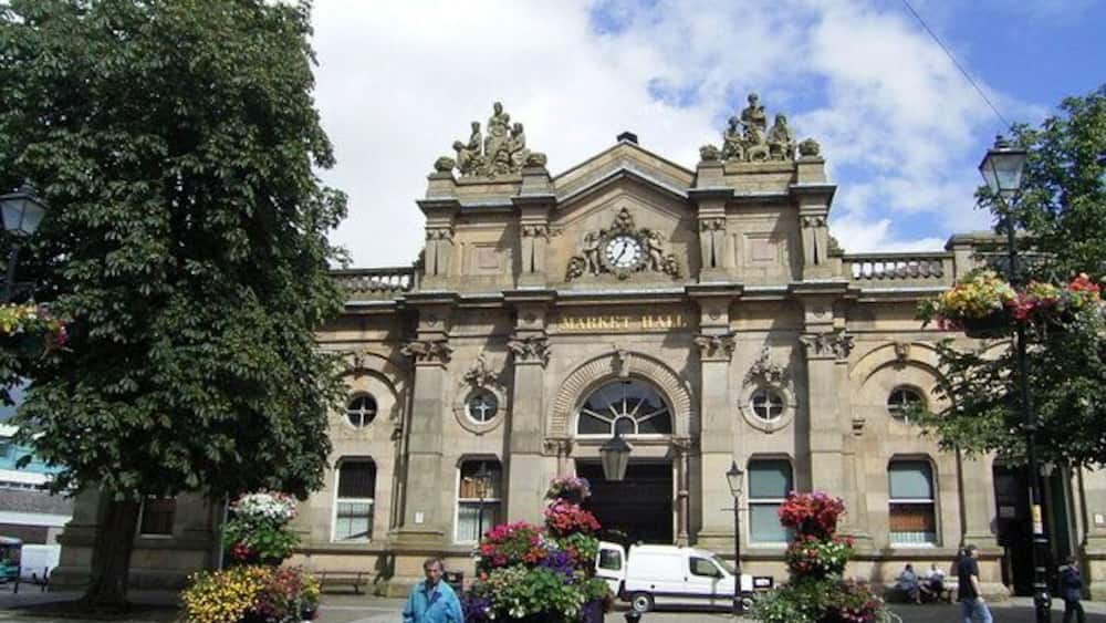 A historic building with ornate architecture, large windows, and statues.