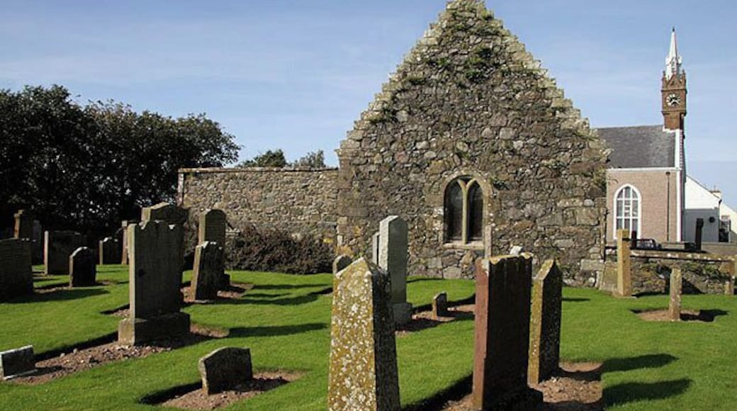Ballantrae Parish Churchyard This is an old area of the churchyard with the Kennedy Mausoleum a prominent feature. The mausoleum was formerly an aisle built against the south wall of an earlier church on this site. The present parish church with clock tower is in the background.
