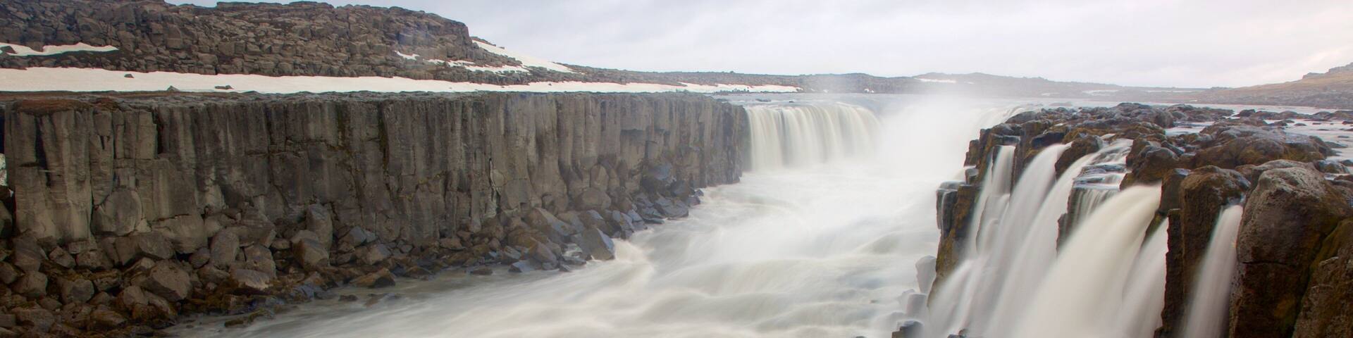 Skinnastadur som inkluderar en ravin eller kanjon, forsar och ett vattenfall