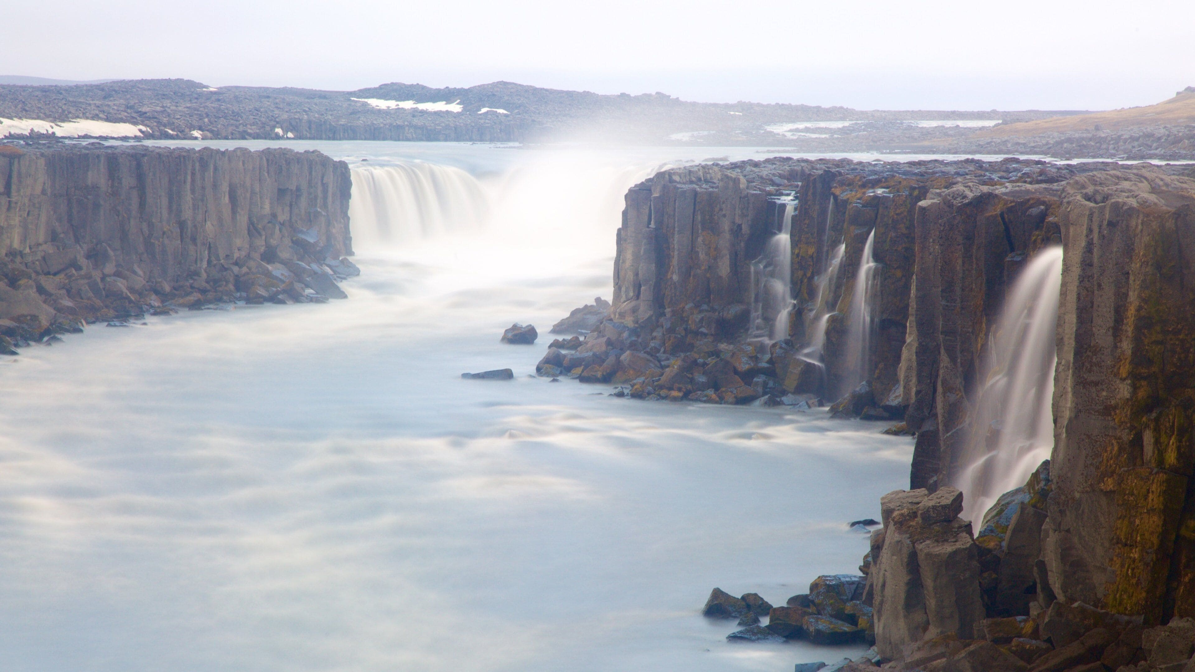 A waterfall cascading down a rocky cliff into a river.