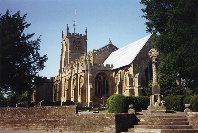 All Saints' parish church, Martock, Somerset, seen from the southeast. The stone cross on the right is the parish war memorial.
