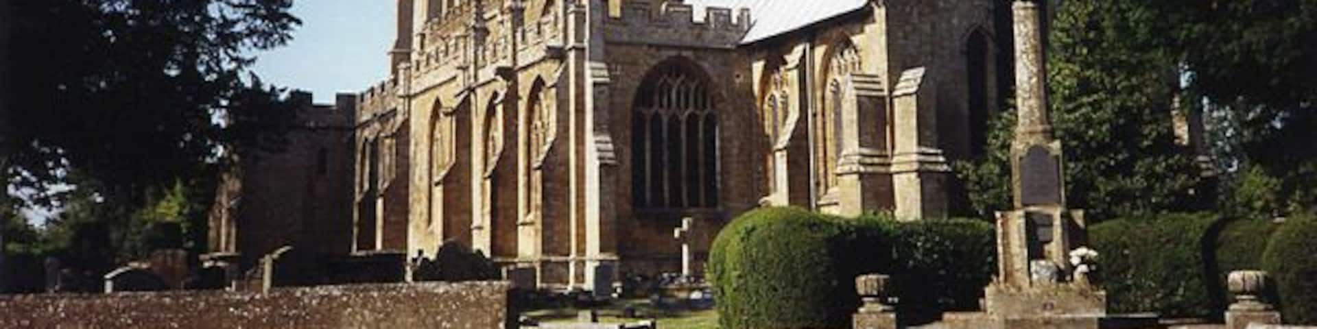 A historic church with a tall bell tower and a large arched window.