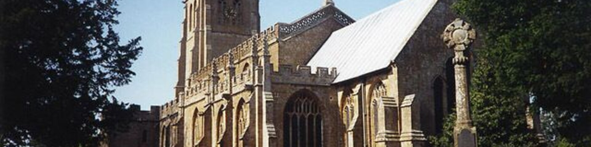 Una iglesia histórica con un alto campanario y un gran ventanal de arco.