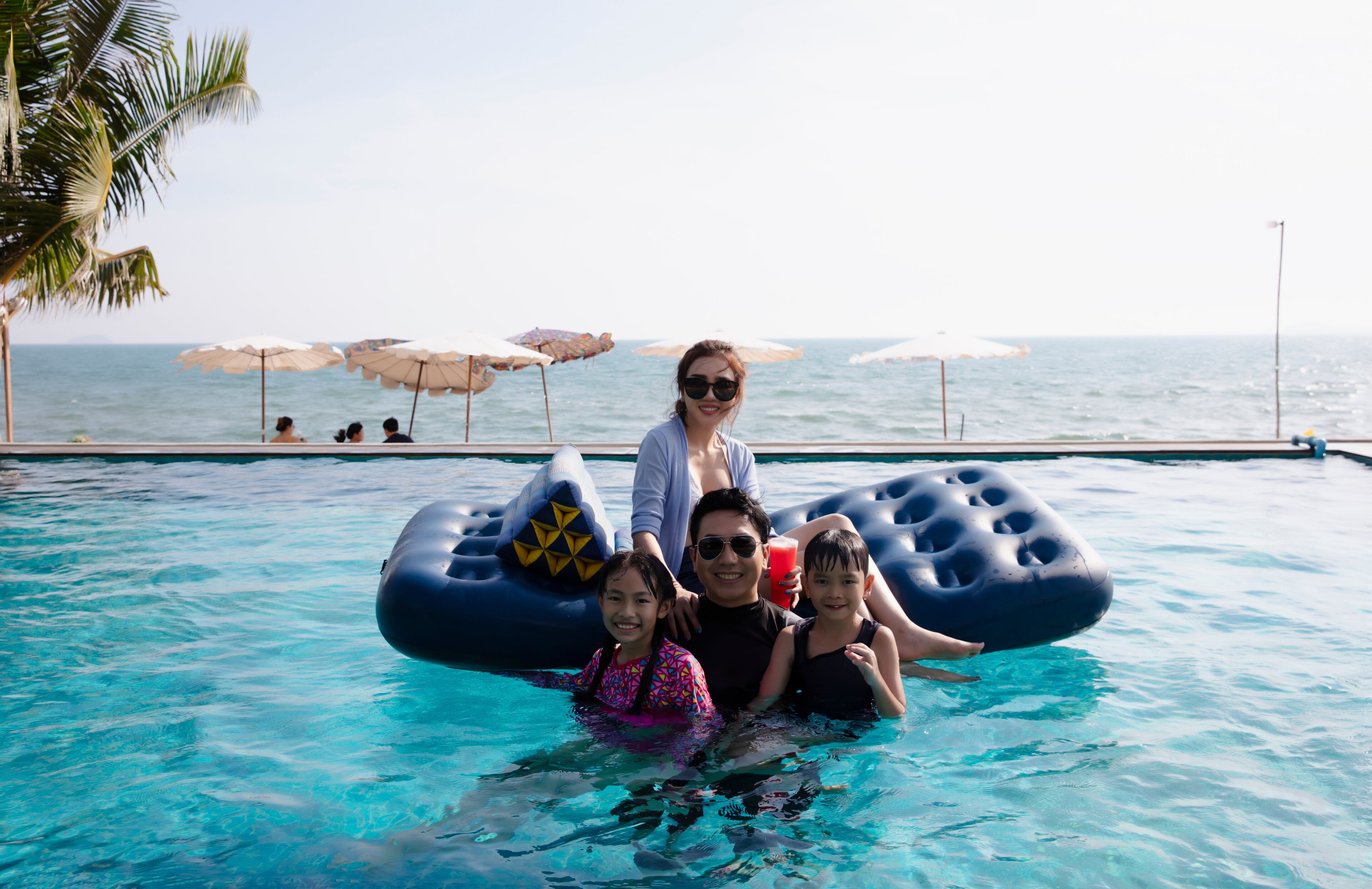 Happy Family enjoy playing together in swimming pool on summer vacation at Rayong, Chonburi of Thailand