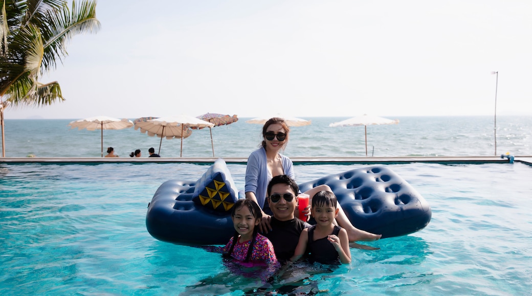 Happy Family enjoy playing together in swimming pool on summer vacation at Rayong, Chonburi of Thailand