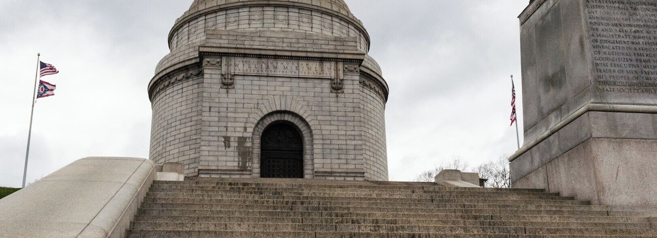 The William McKinley Memorial is a Canton, Ohio landmark, and is the final resting place of the 25th U.S. President and his wife Ida. The site also houses the William McKinley Presidential Library and Museum and a large public park.
McKinley was born in Niles, Ohio but began his career in Canton, the city he called home. McKinley was also the 39th Governor of Ohio. On September 6th 1901, six months into his second term as President, McKinley was shot by a Polish American anarchist. He died 8 days later on September 14th. He was succeeded by his vice president Theodore Roosevelt. The monument, which has 108 steps leading up to its doors, is a very popular destination for area fitness fans who jog up and down the steps throughout the day.
https://mckinleymuseum.org/mckinley-memorial/