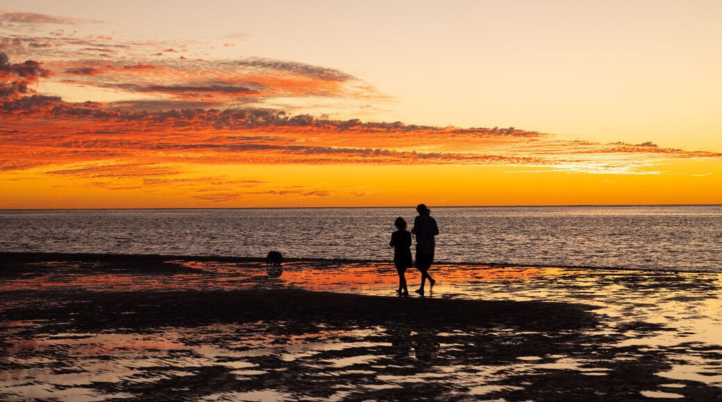 Woman and child walking along beach at sunset in Coral Bay, Western Australia
