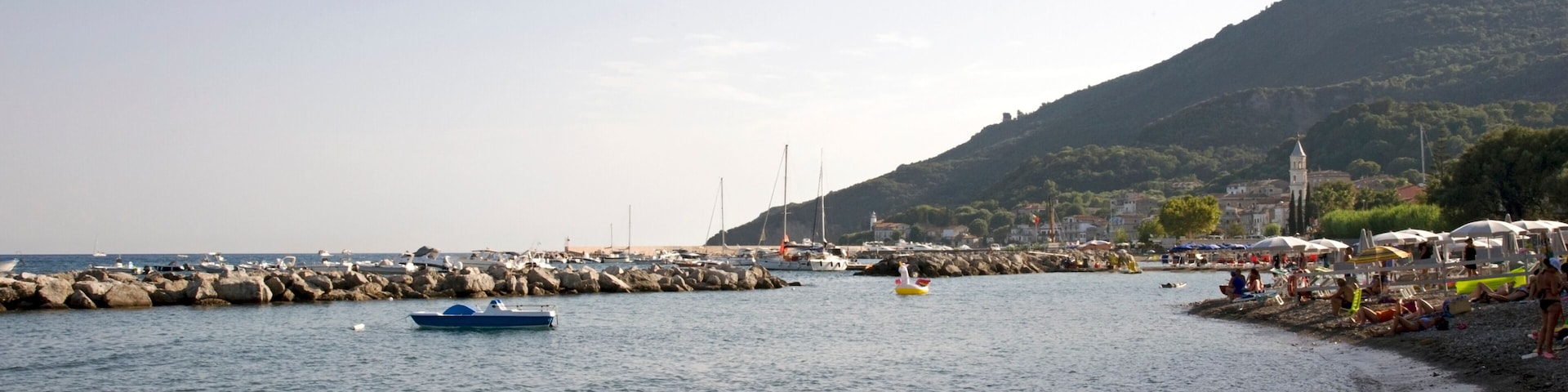 Breakwater and mole with the mount Bulgheria in the background at sunset. Scario village in the Policastro gulf, Salerno, Italy, Europe