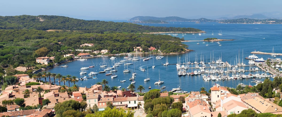 A marina surrounded by lush greenery and coastal buildings.