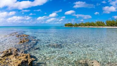 A panorama view from a rocky headland across a deserted bay on the island of Eleuthera, Bahamas on a bright sunny day