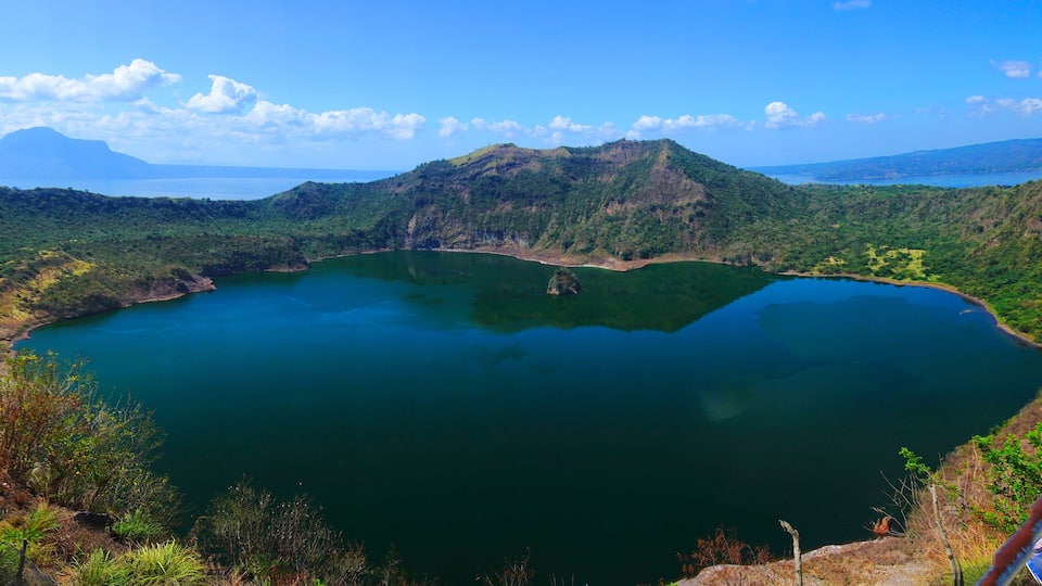 A large lake surrounded by mountains and dense greenery.