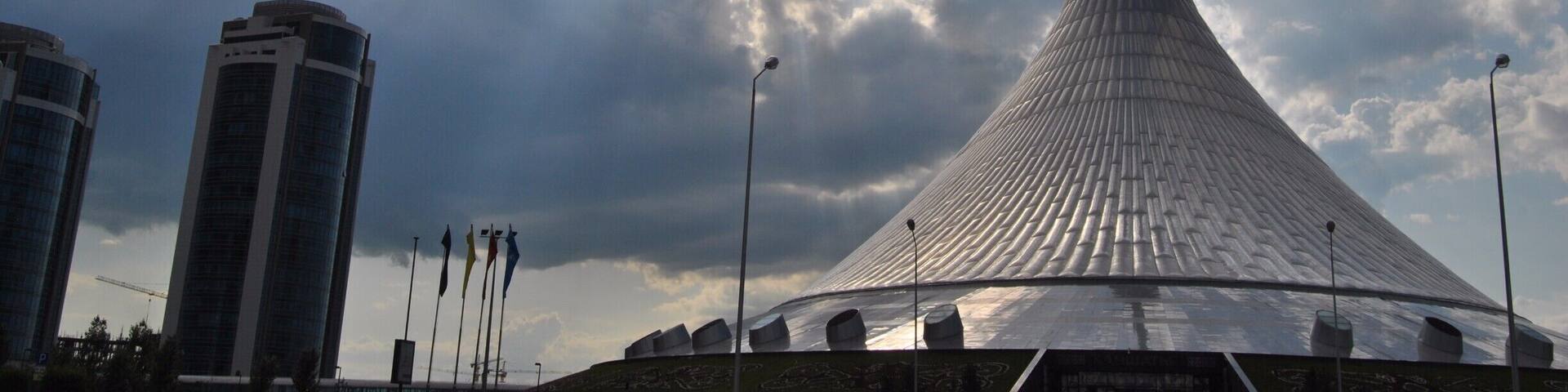 Sun rays beam down around Khan Shatyr just moments before a thunder storm.