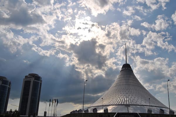 Sun rays beam down around Khan Shatyr just moments before a thunder storm.