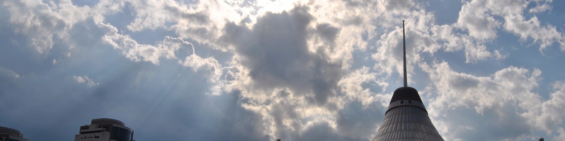 Sun rays beam down around Khan Shatyr just moments before a thunder storm.