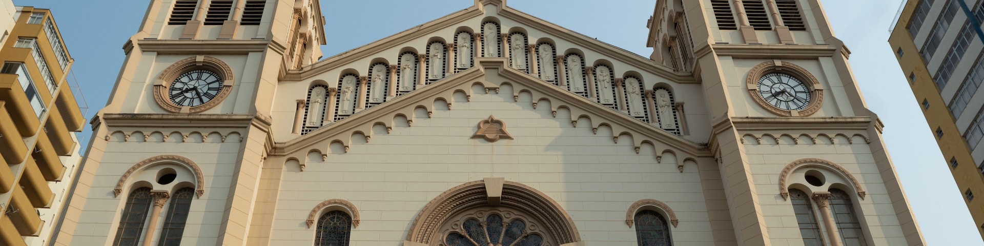 A large church with two towers, each with a clock and a cross at the top.