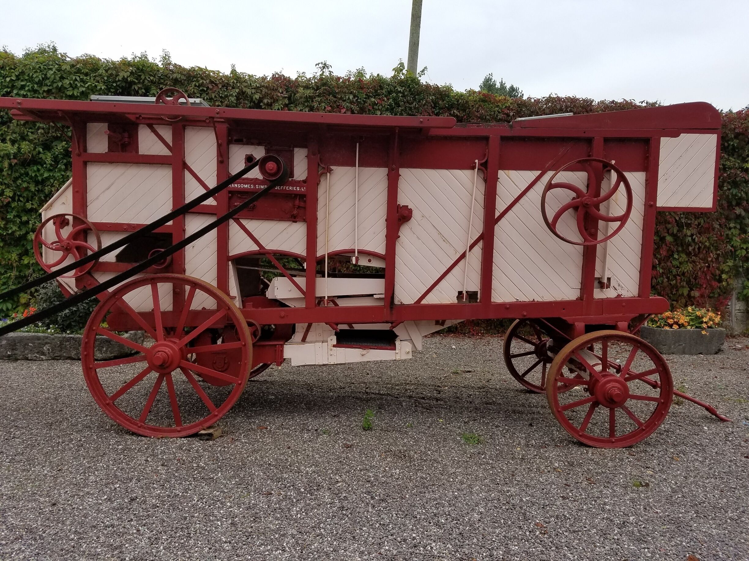A vintage red and white carriage with large wheels.