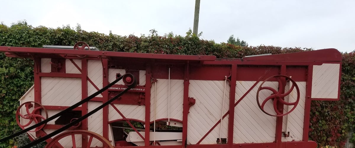 A vintage red and white carriage with large wheels.