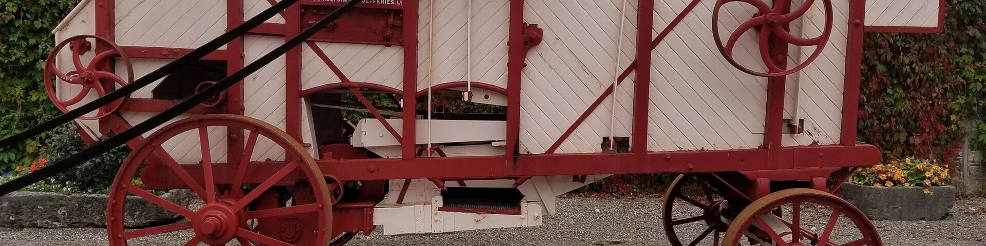 A vintage red and white carriage with large wheels.