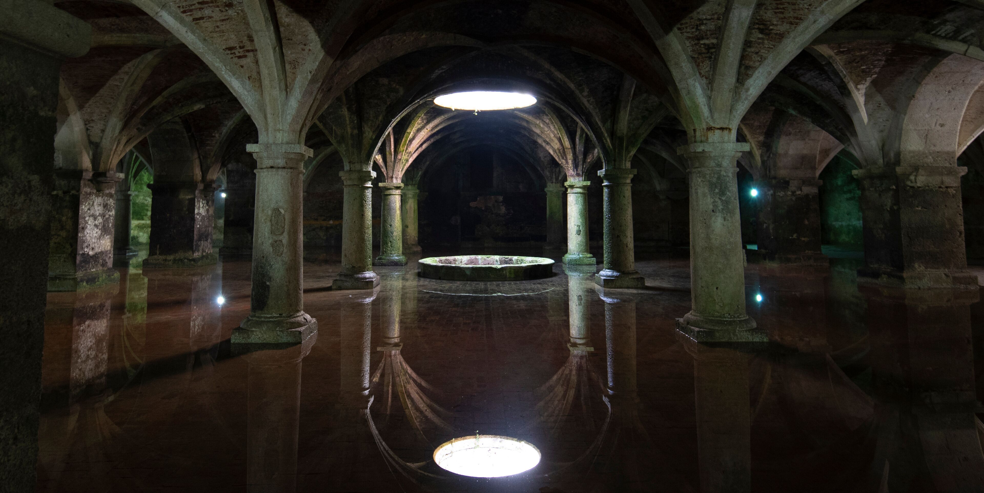 A dimly lit underground chamber with arched ceilings and columns.