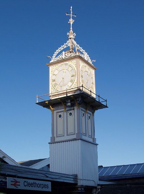 A clock tower with ornate top and a sign for Cleethorpes.