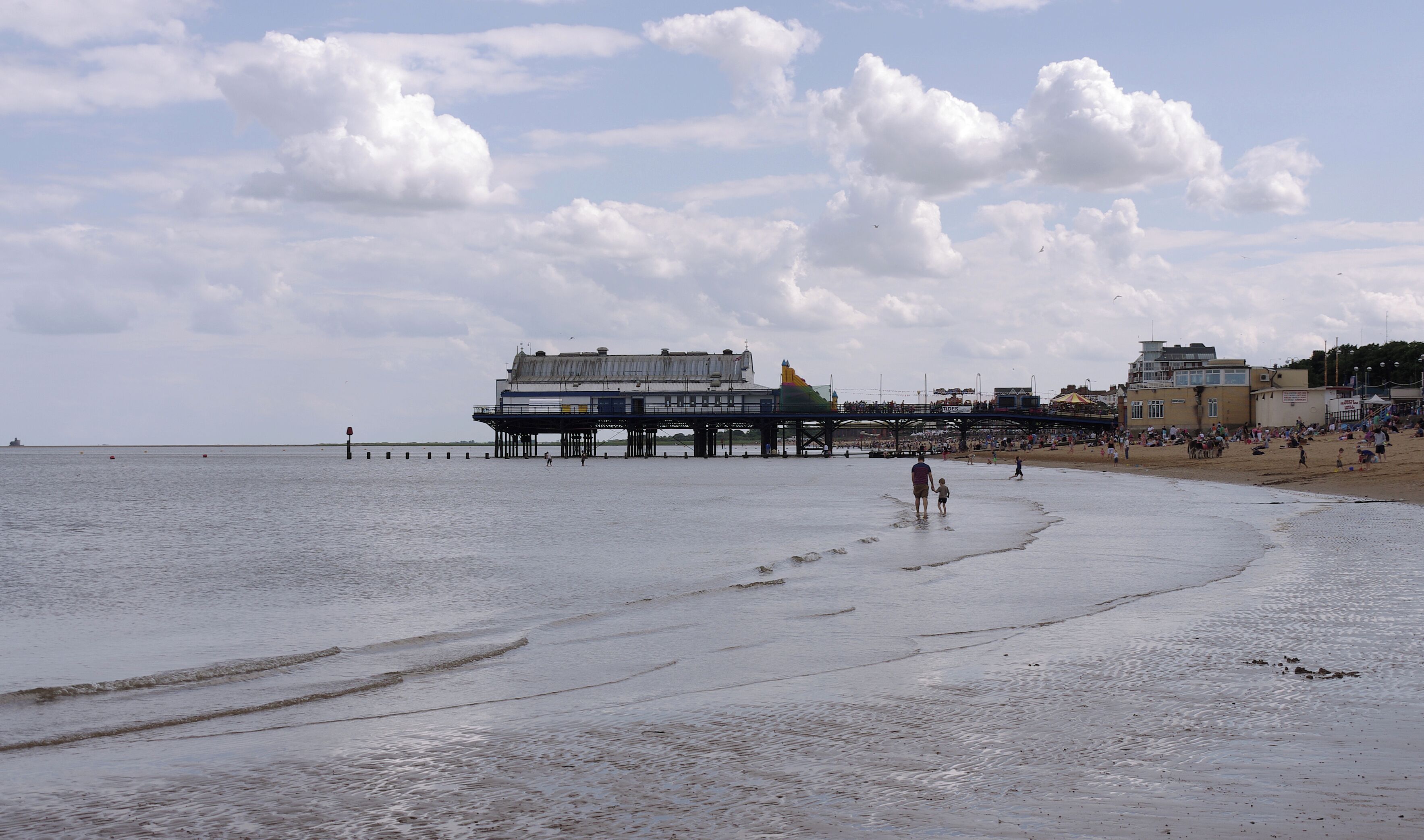 A beach with a pier and a boardwalk.