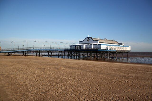 A pier extending into the sea with a building at the end.
