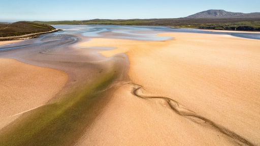 Aerial view of the Durness Estuary where winding waterways carve through the sandy flats under a clear sky, Lairg, Scotland, United Kingdom.