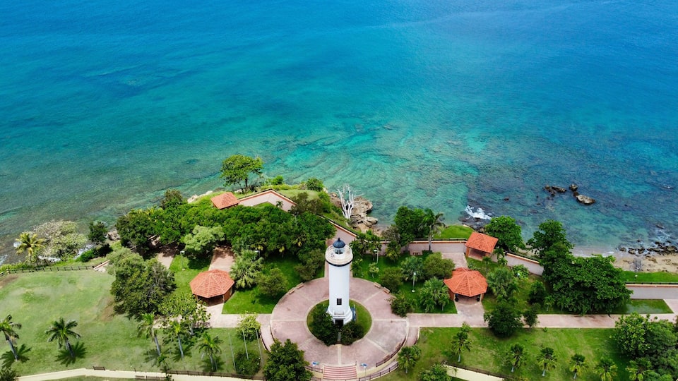 Aerial view of the Rincon Lighthouse along the turquoise water in Puerto Rico
