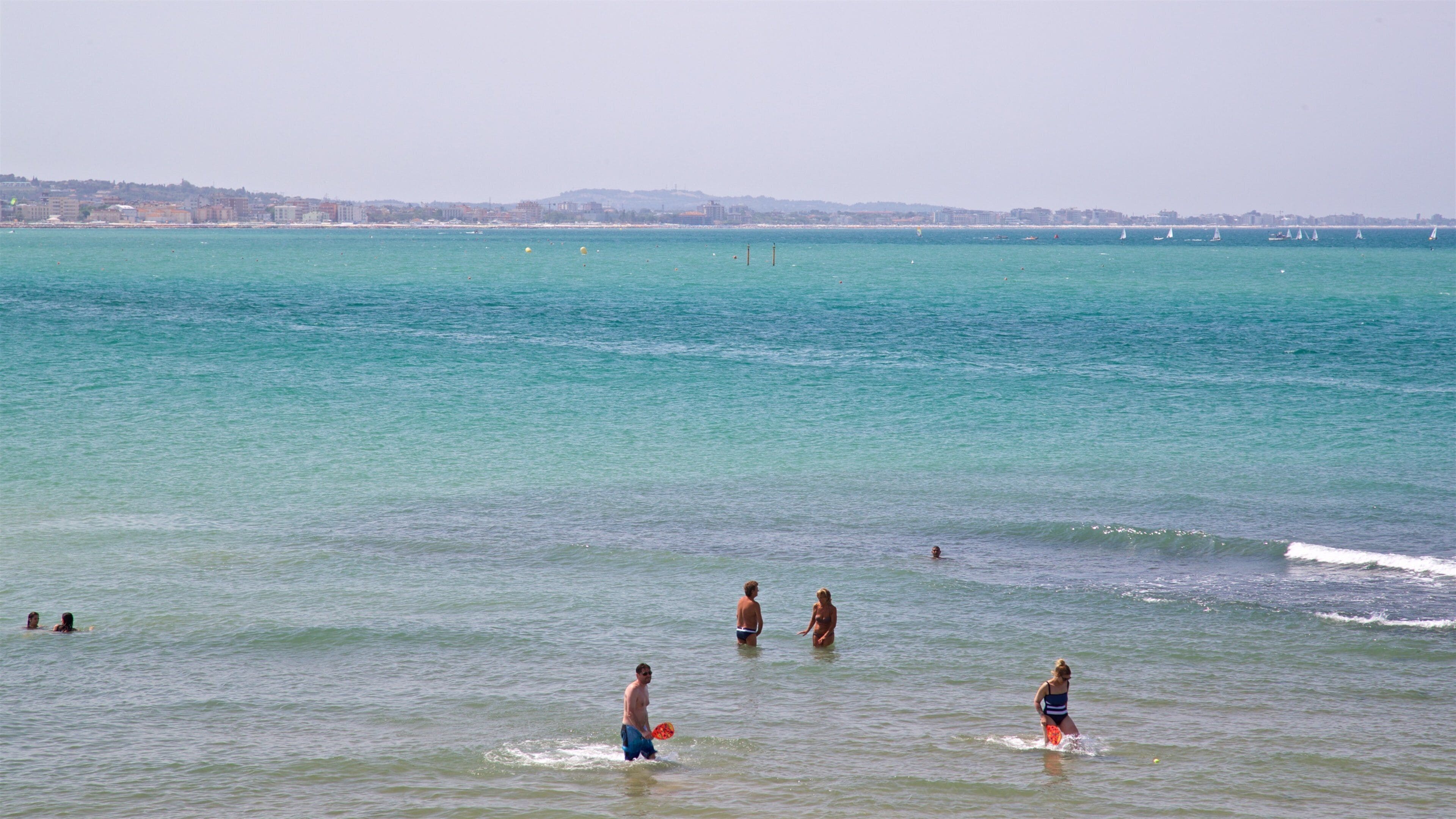 Cattolica que incluye vistas generales de la costa y natación y también un pequeño grupo de personas