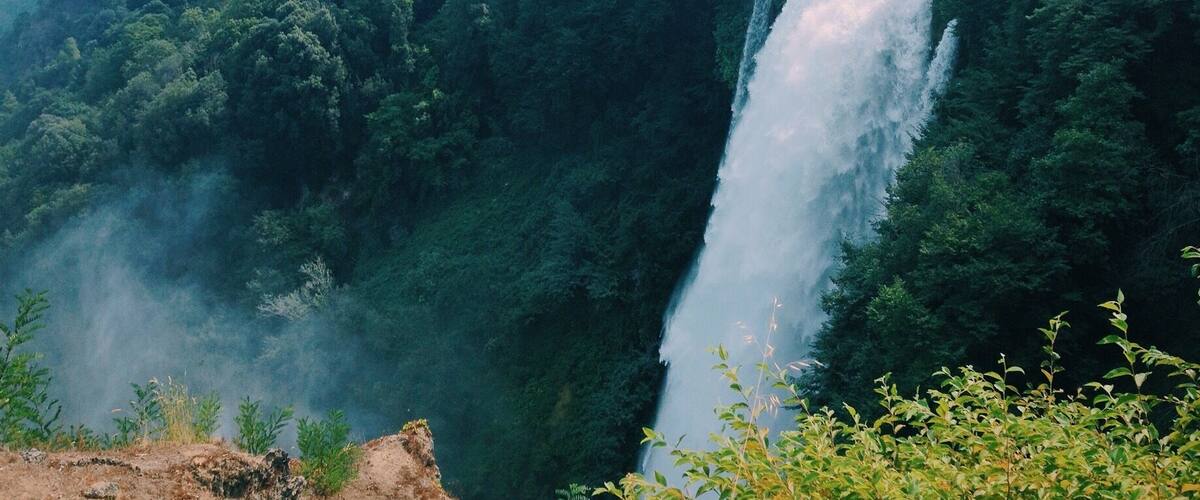 A waterfall cascading down a lush green hillside.