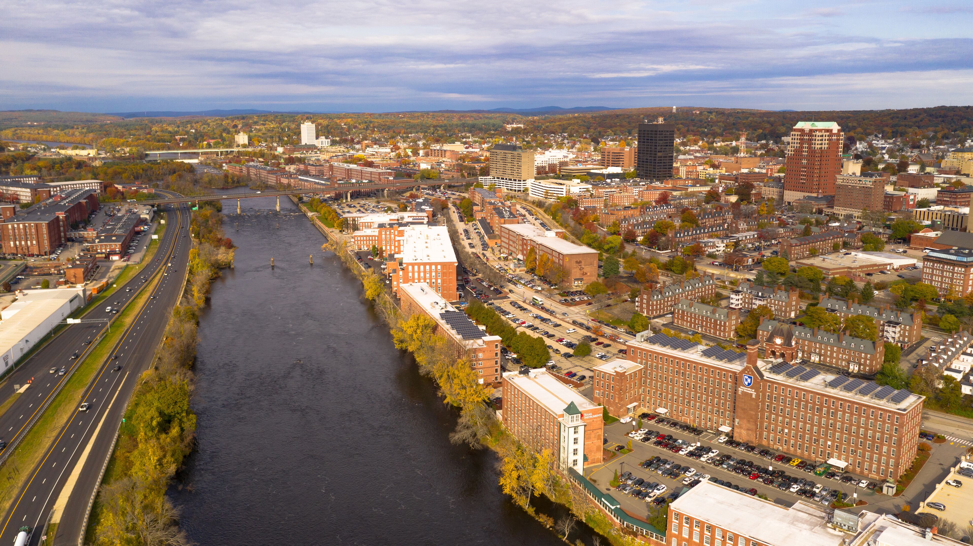 A river flowing through a city with historic buildings and modern skyscrapers.