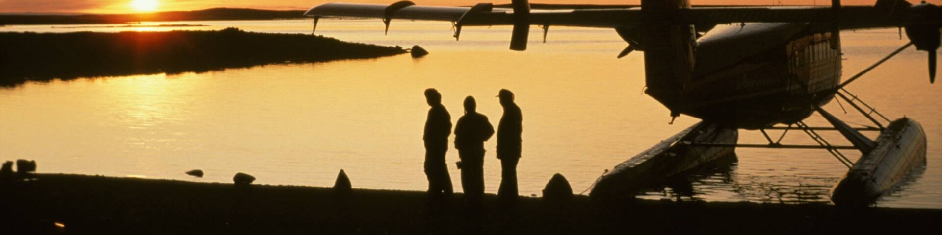 Nunavut mostrando aeronave e um pôr do sol assim como um pequeno grupo de pessoas