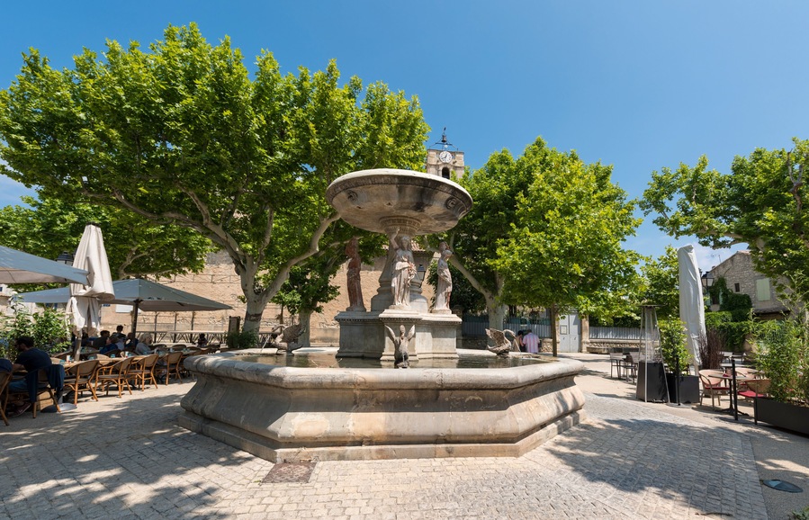 Village square with fountain and restaurant of Maussane les Alpilles. Buches du Rhone, Provence, France; Shutterstock ID 1157625601; Purchase Order: SP-1394 HA Batch 3 Part 1; Order Number: ; Client/L