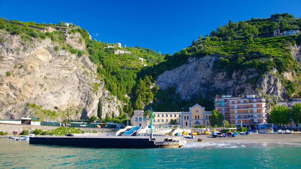 A coastal town with a prominent church, a pier, and buildings on a hillside.