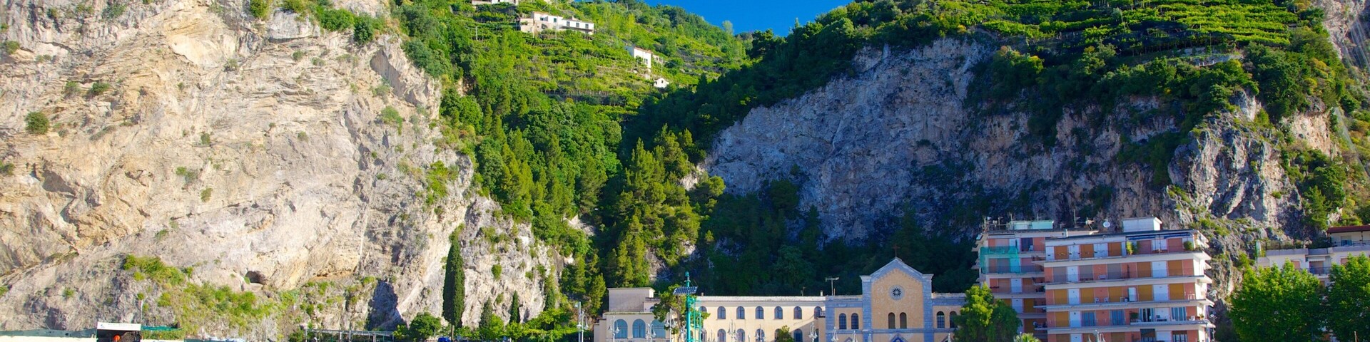 Un pueblo costero con una iglesia destacada, un muelle y edificios en una colina.