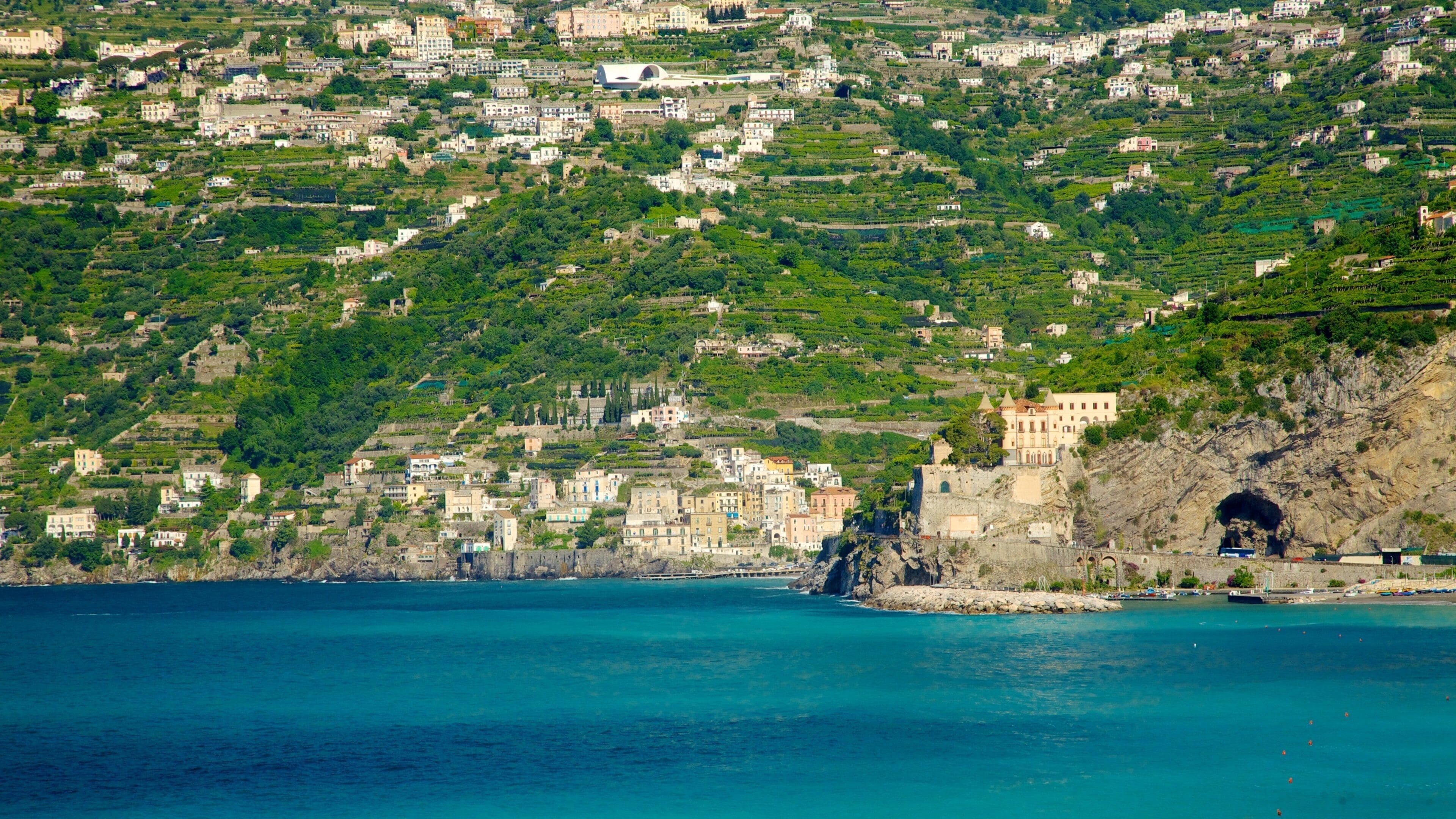 Maiori som viser stenete kystlinje, fjell og by