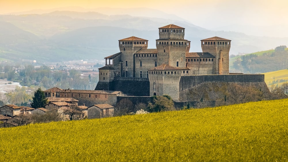 landmarks of italy, the Torrechiara fantasy castle near Parma - Italy with yellow warm toned grass and sky vintage look with copy space