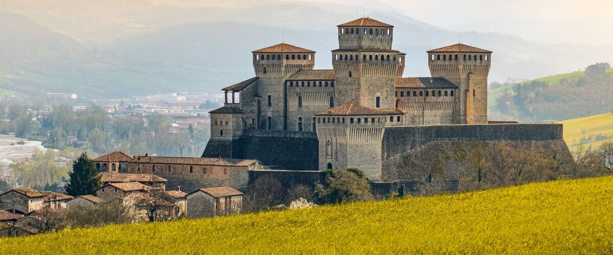 landmarks of italy, the Torrechiara fantasy castle near Parma - Italy with yellow warm toned grass and sky vintage look with copy space
