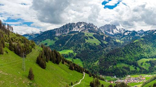 View on alps mountains, green fields, cloudy sky by Jaun, Jaunpass. Canton Fribourg, Freiburg nearby Bulle, Bern, Thun. Good hiking tourist way. Switzerland.