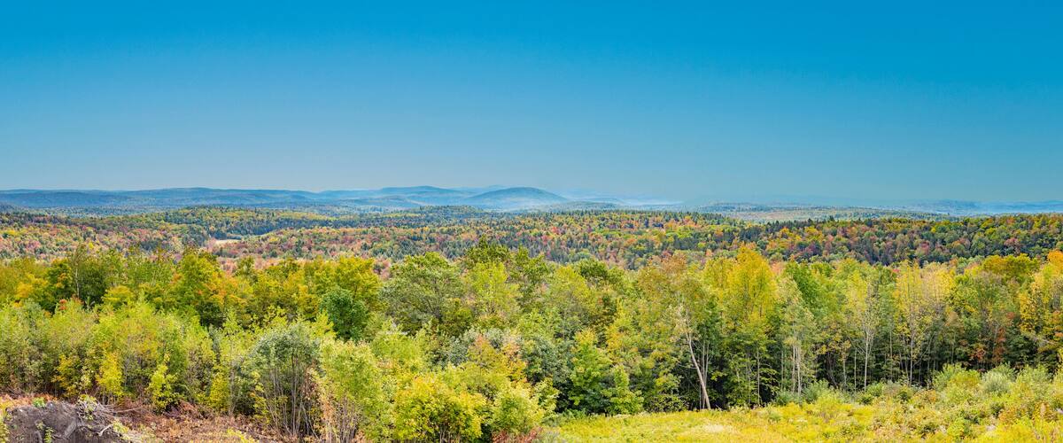 A forested mountain range with autumn foliage.